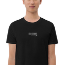 「STAY CURIOUS」刺繍Tシャツ ブラック｜胸元の白い刺繍のアップ。文字からほどけた糸を猫が引っぱっている